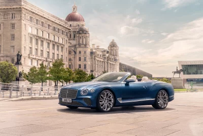 Sleek Blue Bentley Continental Convertible Parked in Elegant Urban Setting, Cinematic Wallpaper image