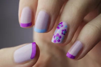 The woman's nails are painted with a light purple polish