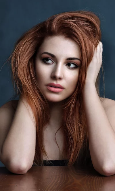 Pensive Young Woman with Red Hair and Captivating Gaze image