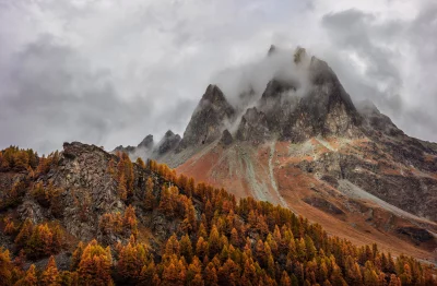 Dramatic Autumn Mountain Landscape with Golden Larch Trees and Cloudy Peaks image