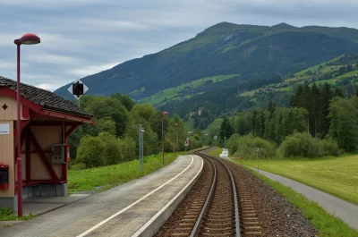 Scenic Alpine Railway Station Tracks Winding Through Green Mountains image