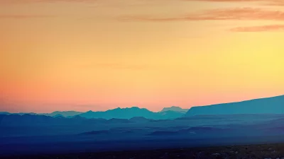 Vast Mountain Landscape with Gradient Twilight Sky and Blue Silhouettes image