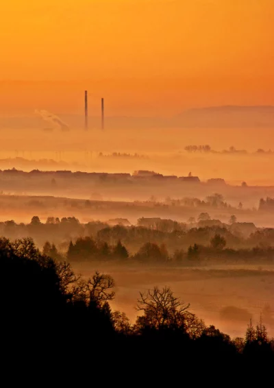 Golden Industrial Sunrise with Atmospheric Fog Over Rural Layered Landscape image