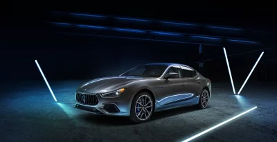 Sleek Gray Maserati Luxury Electric Car Under Dynamic Blue Neon Lighting Wallpaper image