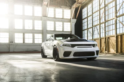 Sleek White Dodge Charger SRT in Industrial Hangar Sunlight image