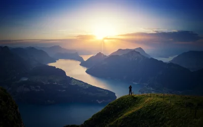 Hiker Capturing Majestic Mountain Lake Sunset Panorama image