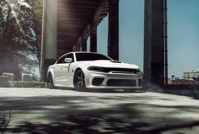 Powerful White Dodge Charger Parked Under Urban Bridge with Dramatic Sun Rays Cinematic Style image