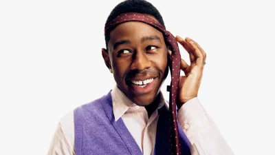 Tyler, the Creator Joyfully Adjusting Patterned Tie as Headband in Studio image