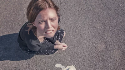 Disgusted Young Woman Reacting to Spilled Dessert on Asphalt Pavement image