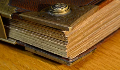 Antique Leather Book with Ornate Metal Clasp and Aged Pages on Wood image