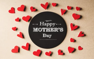 Happy Mother's Day message on black circle surrounded by small red paper hearts image