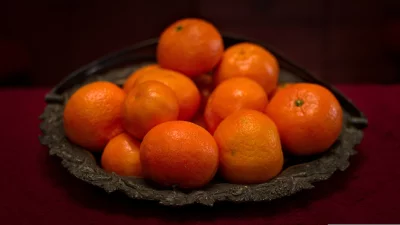 Fresh Orange Tangerines in Rustic Metal Bowl on Deep Red Fabric image