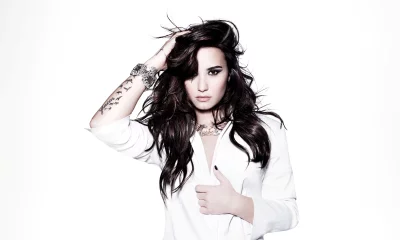 Glamorous Young Woman with Long Wavy Dark Hair Posing in White Blazer image