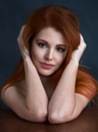 Captivating Redhead Woman with Emerald Eyes Posing with Hands Near Head image