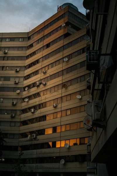 Exterior of Modern Building with Satellite Dishes and AC Units at Dusk