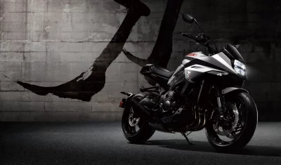 Sleek Dark Grey Suzuki Katana Motorcycle with Illuminated Headlight on Urban Background image