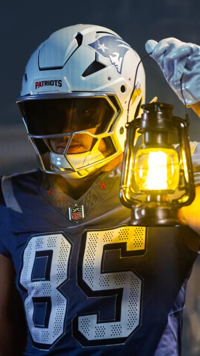 New England Patriots Football Player with Helmet Holding Glowing Lantern in Darkness