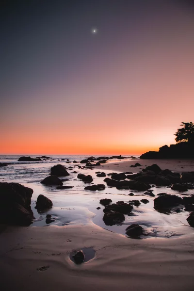 Vibrant Twilight Beach Landscape with Moon and Ocean Rocks image