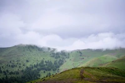 Misty Mountain Landscape with Green Hills and Rolling Clouds