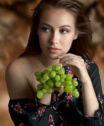 Young Woman Posing with Fresh Green Grapes, Elegant Floral Dress image