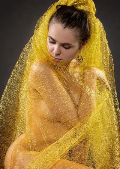 Ethereal Golden Veiled Woman in Artistic Portrait with Shimmering Fabric image