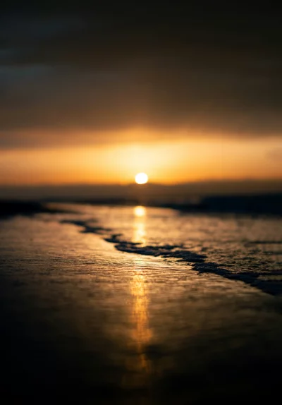 Serene Beach Sunset with Golden Sunlight Reflecting on Gentle Waves