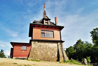 Unique Mountain Building with Radio Tower Against Clear Blue Sky image