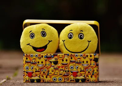 Smiling Yellow Emoji Plush Toys in Box Cheerful Expression Fun Concept Stock Photo image