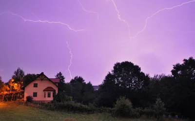 Dramatic Purple Sky with Lightning Strikes Over Rural House and Forest image