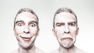 Man Portraying Contrasting Emotions of Joy and Sadness with White Face Paint image