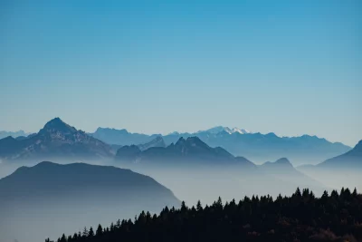 Layered Mountain Range with Atmospheric Haze and Clear Blue Sky image