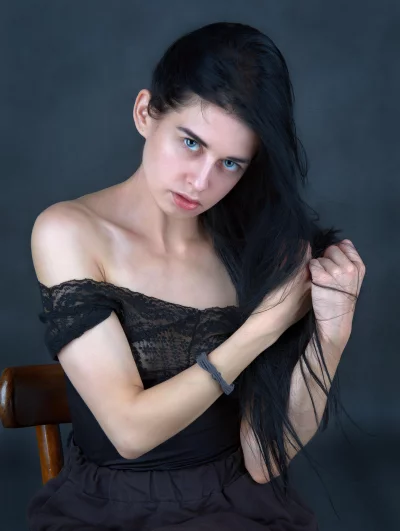 Captivating Young Woman with Striking Blue Eyes and Flowing Dark Hair Posing image