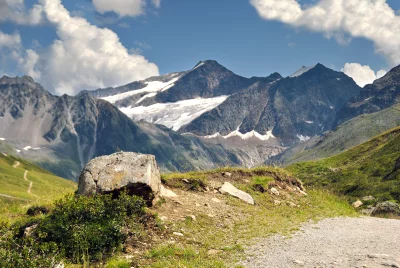 Majestic Alpine Landscape with Glacial Peaks, Green Valleys, and Rocky Terrain image