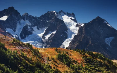 Majestic Alpine Peaks and Autumn Forest with Glaciers under Clear Blue Sky image