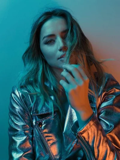 Expressive Female Model Posing Under Dynamic Blue and Orange Light image