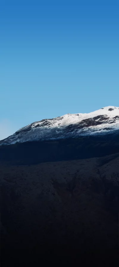 Sunlit Snow-Capped Mountain Under Clear Blue Sky