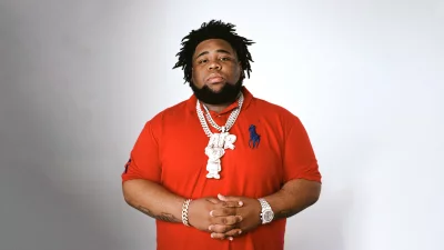 Confident Male Rapper Rod Wave in Red Polo Shirt and Diamond Chains Posing image