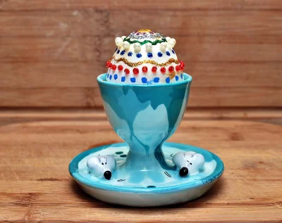 Decorated Easter Egg in Whimsical Mouse Egg Cup on Rustic Wooden Surface image