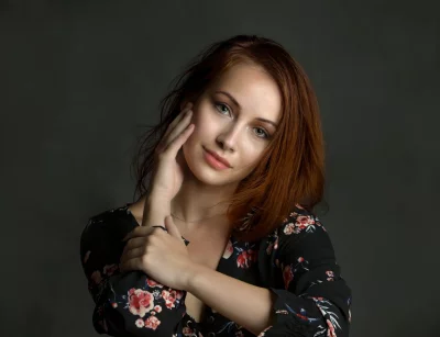 Red-Haired Woman in Floral Top, Pensive Studio Portrait image