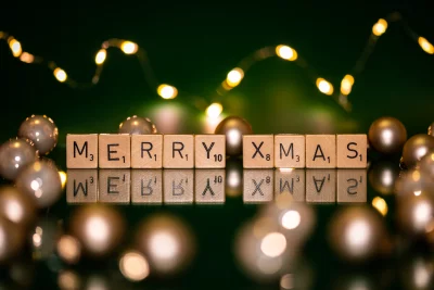 Festive Holiday Display with 'Merry Xmas' Scrabble Tiles, Golden Ornaments, and Bokeh Lights image