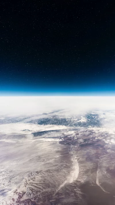 Earth's Majestic Horizon from Space with Starry Night Sky and Snow-Covered Peaks image