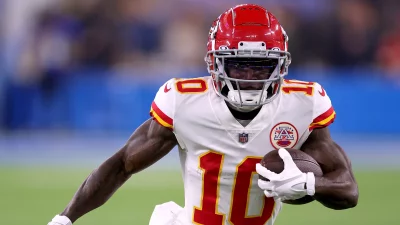 Dynamic American Football Player Carries Ball in Red and White Uniform on Field image