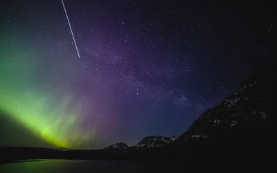 Vibrant Aurora Borealis and Milky Way Illuminate Snowy Mountains with Satellite Streak image