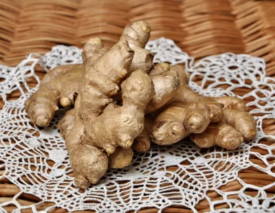 Fresh Organic Ginger Roots on Rustic Wicker and White Crochet Doily Background image
