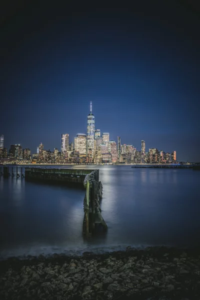 Stunning New York City Skyline at Night from Hudson River with Illuminated Skyscrapers and Calm Water image
