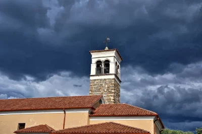 Historic Church Bell Tower Under Dark Dramatic Storm Clouds image