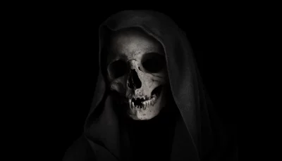 Eerie Human Skull Shrouded in Dark Hood Against Black Background for Horror image