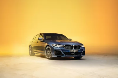 Sleek Blue BMW Alpina 5 Series Sedan Studio Shot on Yellow Background image