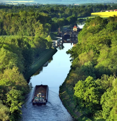 Aerial View of Cargo Barge on Serene Forested Canal Approaching Locks image