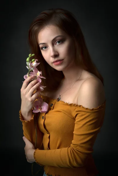 Serene Young Woman Holding Delicate Pink Orchids Portrait image